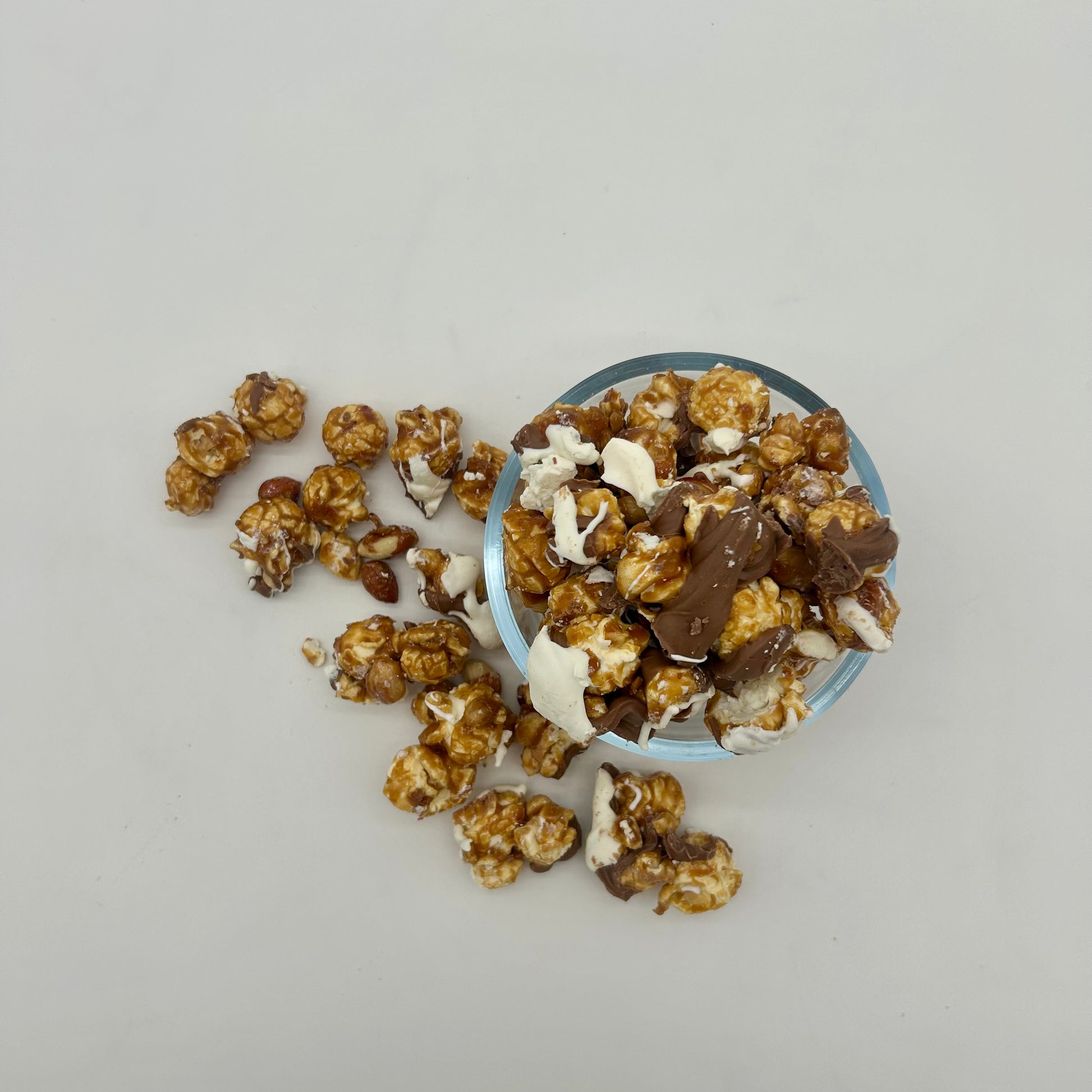 Homemade Caramel corn and roasted Spanish peanuts drizzled with milk and white chocolate.